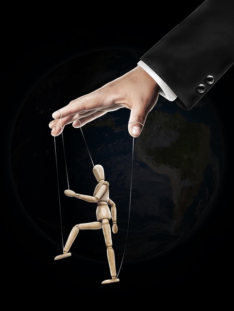 Hand, an der eine Marionette bewegt wird